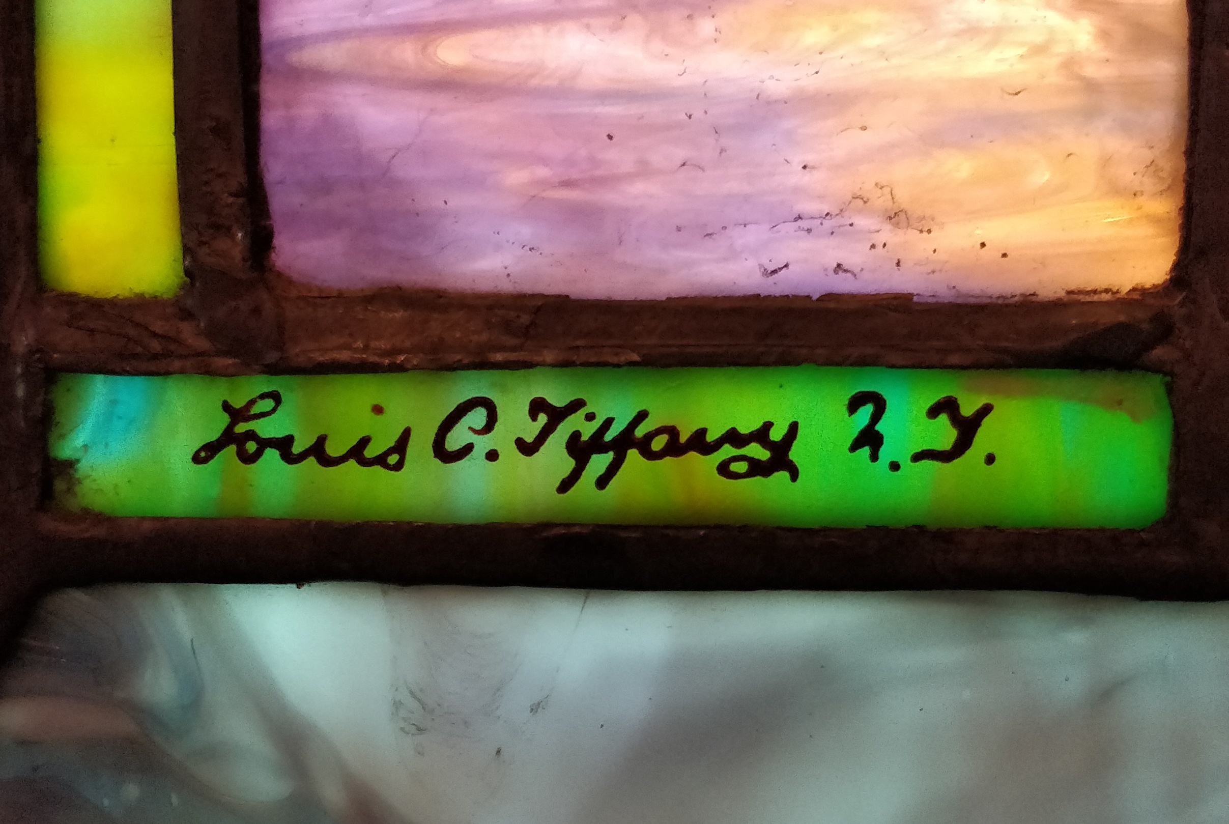 Louis C. Tiffany's signature on a stained glass window